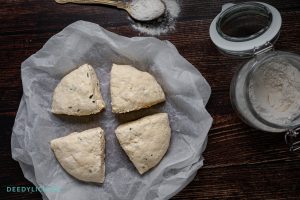 Deeg voor bagels verdeeld in 4 gelijke stukken op een houten ondergrond.