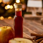 Flesje Apple Crisp koffiesiroop met daarnaast stukjes appel en stokjes kaneel