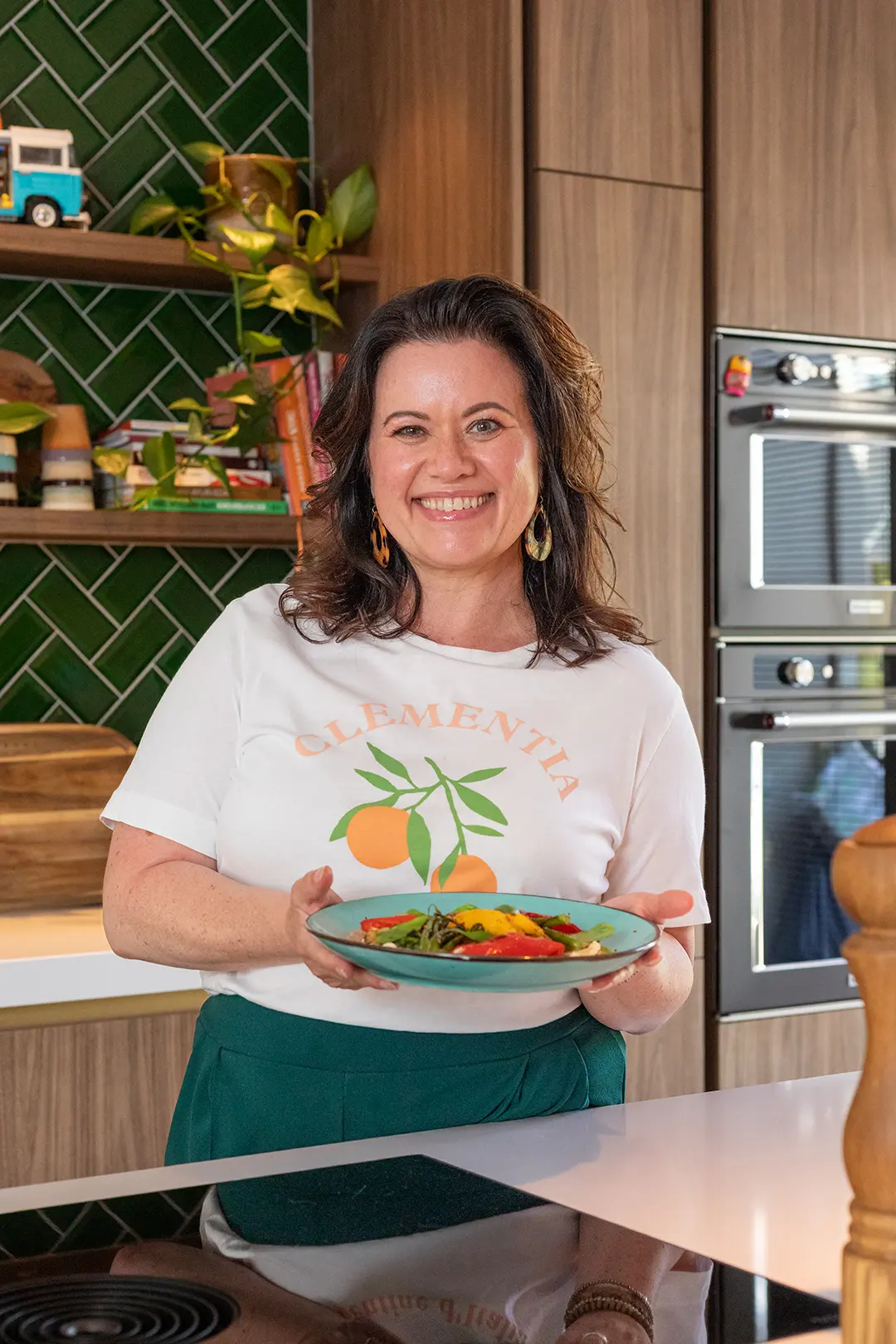 Foodblogger Francesca Kookt in een houten keuken met groene achterwand, die wat te eten staat op te scheppen.